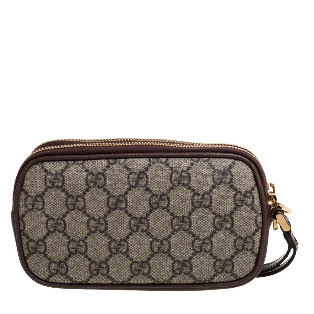 Add class to your look by accessorizing with this Gucci pouch. Designed expertly, this wristlet pouch features a GG Supreme canvas body enhanced with leather trims. The piece flaunts signature GG on the front along with the iconic web detailing. It