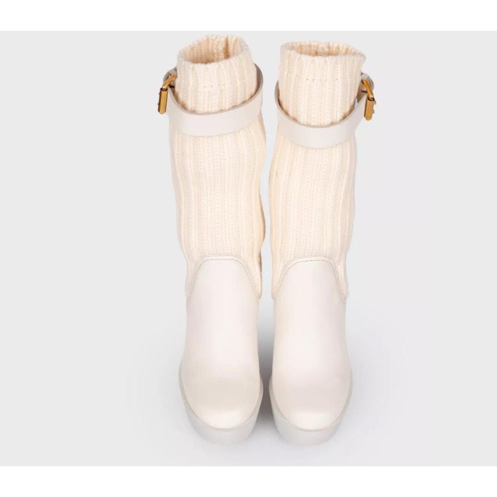 Eleva tu estilo con estas modernas botas calcetín de Gucci, confeccionadas en una mezcla de elegante tejido negro y piel. Diseñadas con una silueta entallada y un cómodo tacón de cuña alta, estas botas son perfectas para añadir un toque de lujo a tu