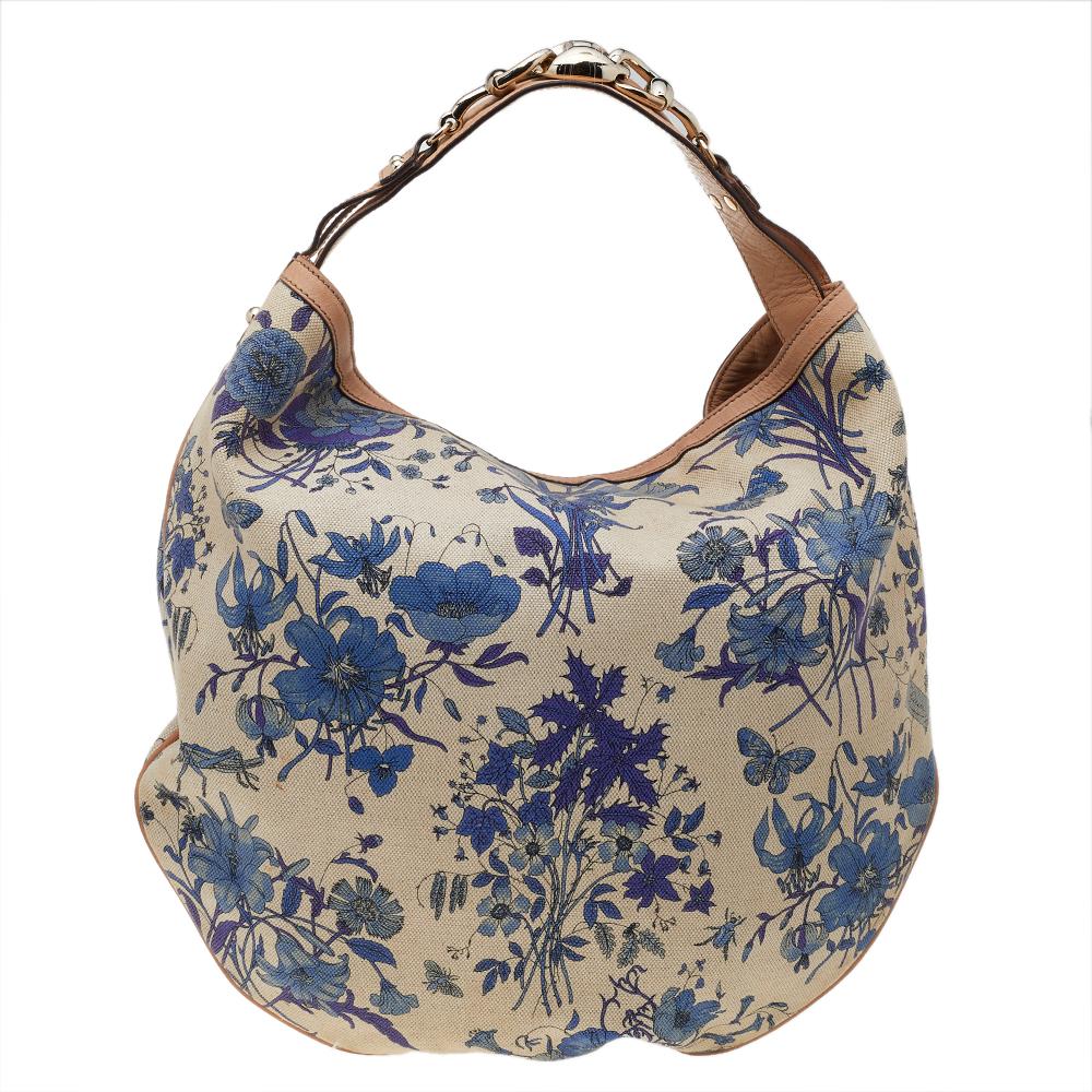 Gucci's handbags are not only well-crafted but are also coveted because of their high appeal. This hobo bag, like all of Gucci's creations, is fabulous and closet-worthy. It has been crafted from beige floral printed canvas and leather and styled