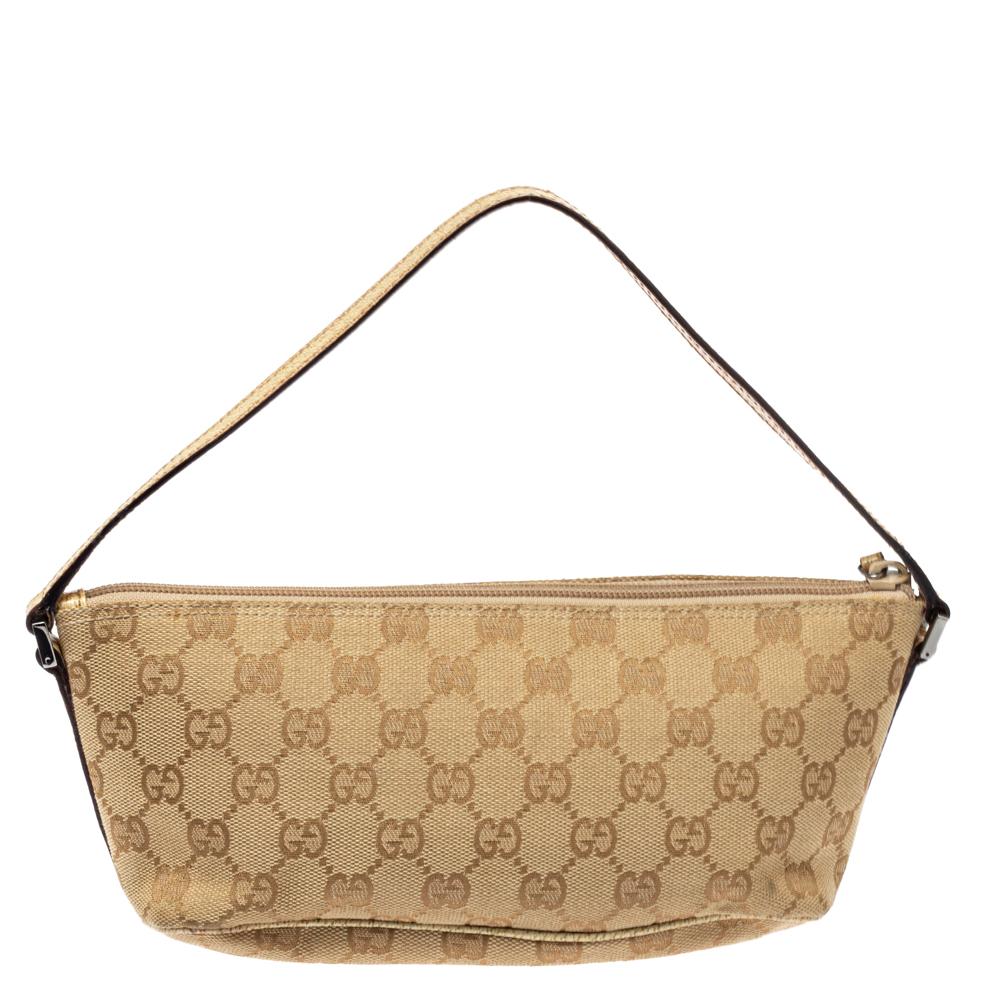 This handy boat-shaped Pochette bag is from the house of Gucci. It has been crafted in Italy and made from signature GG canvas and leather. It comes in a beige hue and is equipped with a nylon interior, which will house the essentials. The pochette