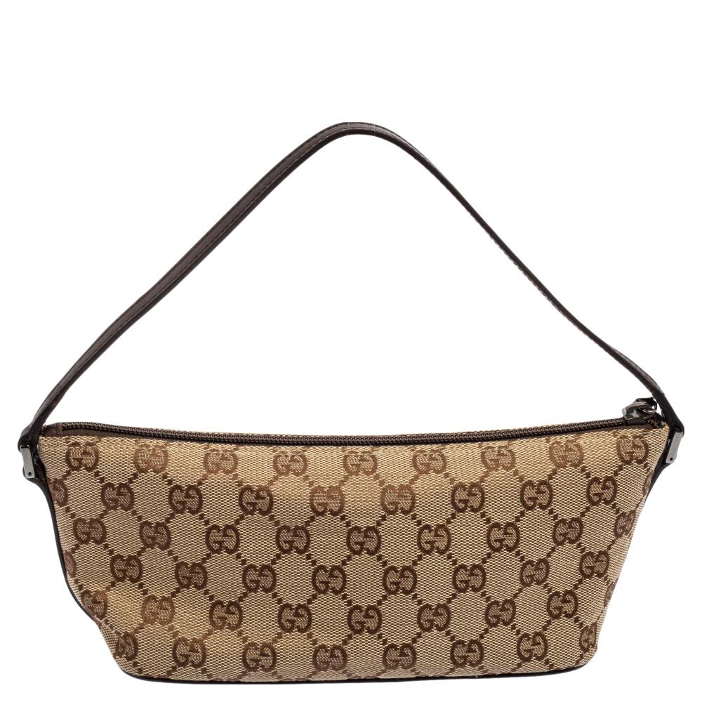 This handy boat-shaped Pochette bag is from the house of Gucci. It has been crafted in Italy using signature GG canvas and leather. It is equipped with a nylon interior that will house the essentials you cannot do without. The pochette is complete