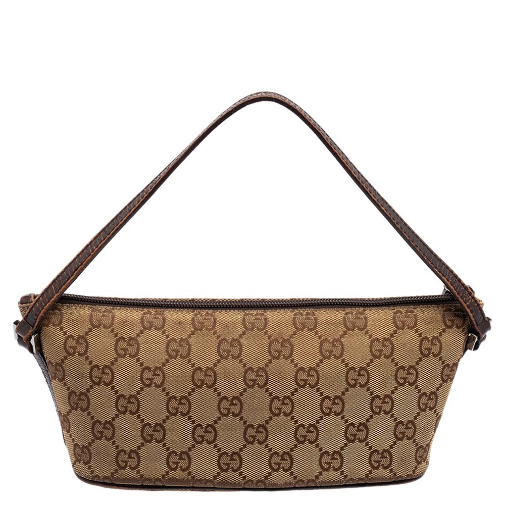 This Boat Pochette bag comes from the House of Gucci. Designed using beige GG canvas and leather on the exterior with a logo accent perched on the front. It features a nylon-lined interior, gunmetal-toned hardware, and a single handle. Carry this