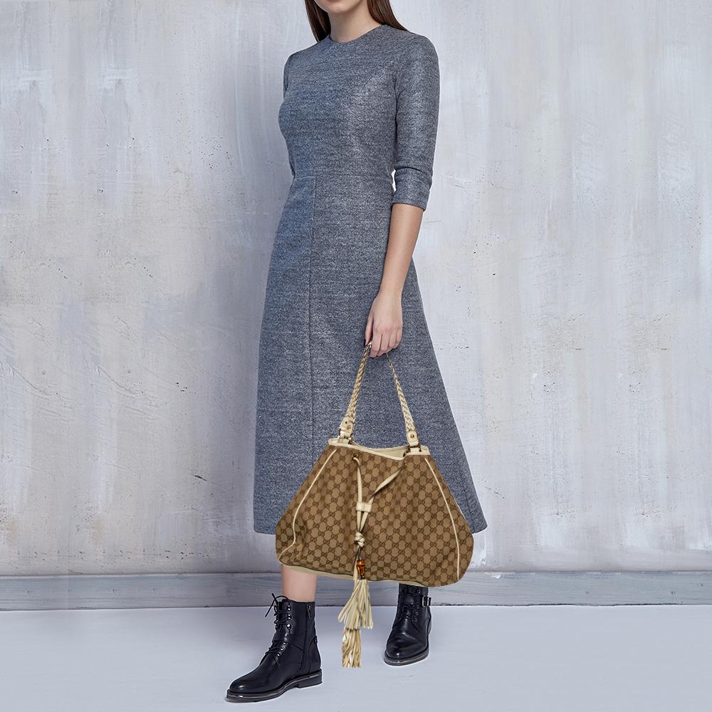 Light up your look with this Preggy tote from Gucci. Crafted from classic GG canvas, it has a bamboo tassel detailing on the front. The fabric-lined interior is spacious enough to hold your daily necessities. The bag is complete with protective