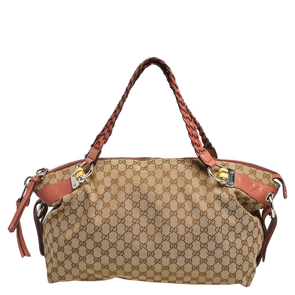 Metti fine alla tua ricerca della tote perfetta con questo favoloso pezzo di Gucci. Questa borsa è realizzata in tela GG e in pelle e presenta due manici intrecciati e un interno foderato in tessuto abbastanza spazioso per trasportare i tuoi oggetti