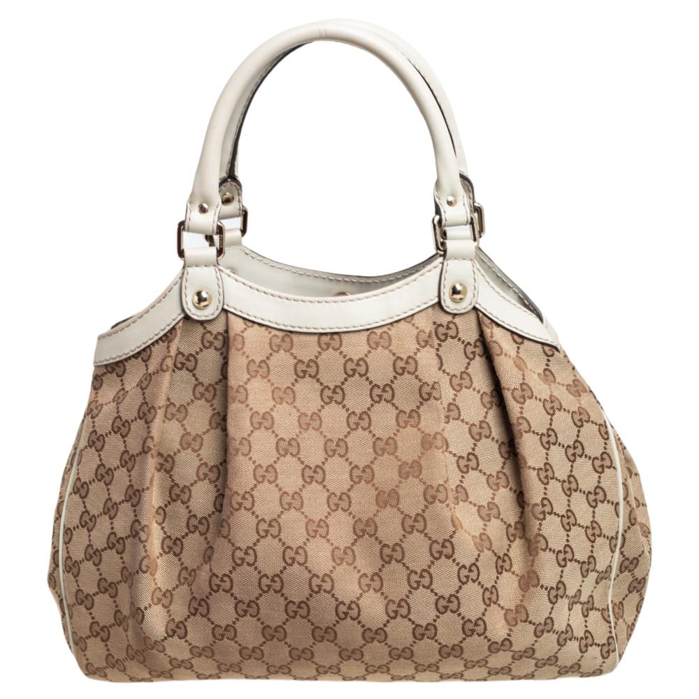 Die Sukey ist eines der meistverkauften Modelle von Gucci:: und wir sind der Meinung:: dass auch Sie es verdient haben:: eine zu besitzen. Die aus GG Canvas und Leder in Beige gefertigte und mit einem geräumigen Innenraum ausgestattete Tasche ist