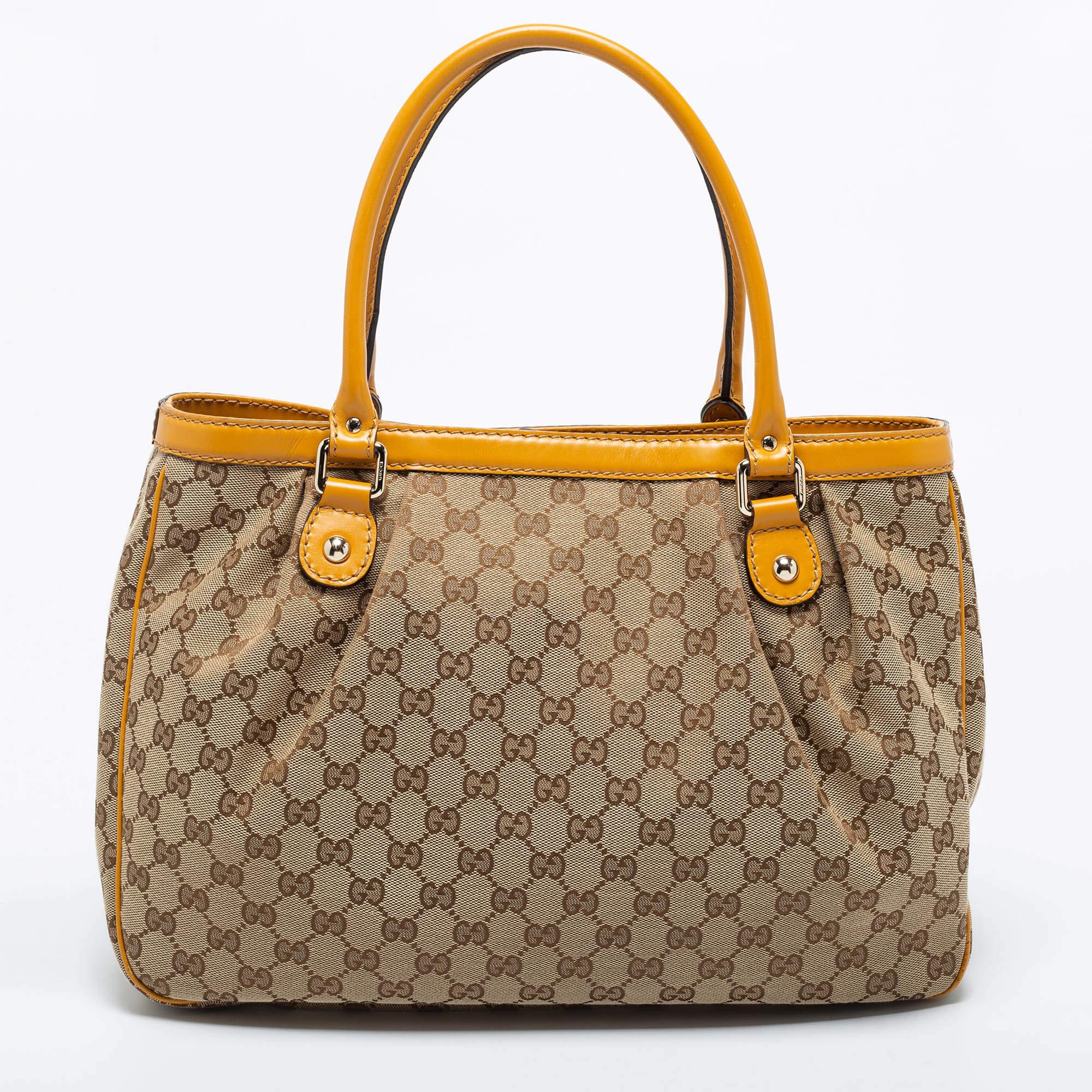 Enriched with signature details, this Sukey hobo from Gucci will surely win your vote as a favorite. It comes crafted from GG canvas and leather and flaunts dual handles at the top, a branded charm, and neat pleats. Lined with canvas, it is capable