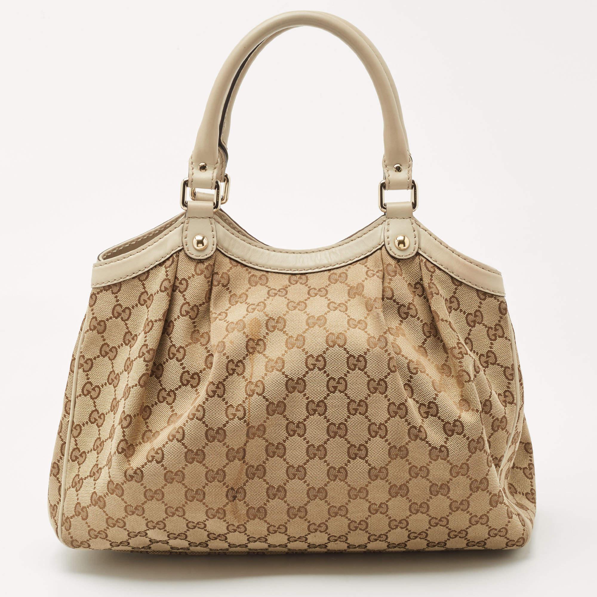 Enriched with signature details, this Sukey hobo from Gucci will surely win your vote as a favorite. It comes crafted from GG canvas and leather and flaunts dual handles at the top, a branded charm, and neat pleats. Lined with fabric, it is capable