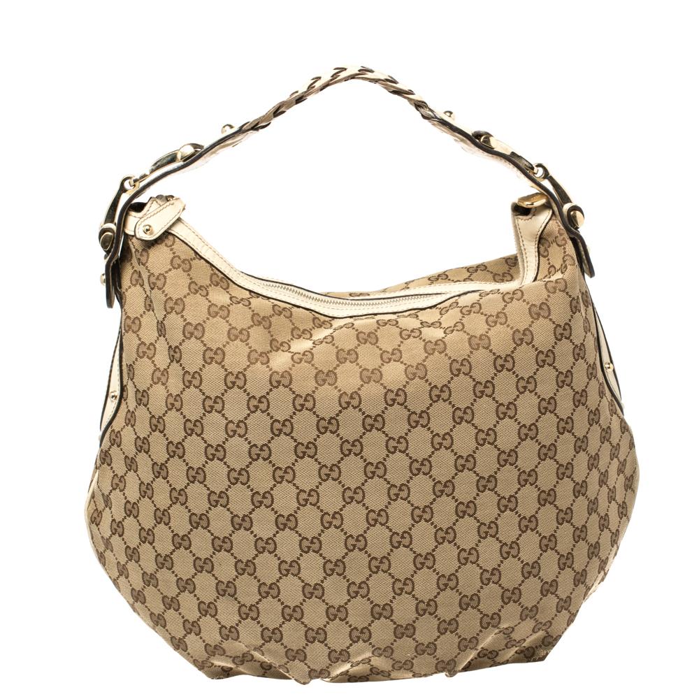 An absolute delight, this Pelham bag is a Gucci creation. It has been crafted from beige-hued GG canvas & leather and enhanced with gold-tone detailing. It comes with a fabric-lined interior that houses a zip pocket, and the bag is complete with a