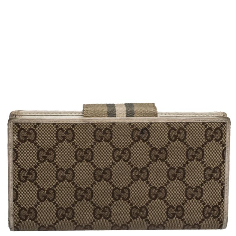 Store all your essentials in this wallet from Gucci. It is crafted from GG canvas and leather with a front closure that flaunts the web detailing. The nylon and fabric-lined interior features multiple credit card slots and open compartments. It is