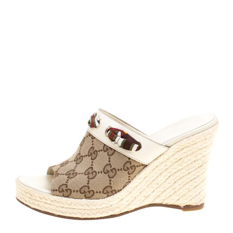 Grab these Gucci sandals that will get you that sexy and casual look. Featuring GG coated canvas strap on the front along with leather trims that are further accented with fabric trims, these slides have open peep toes, leather-lined insoles and 11