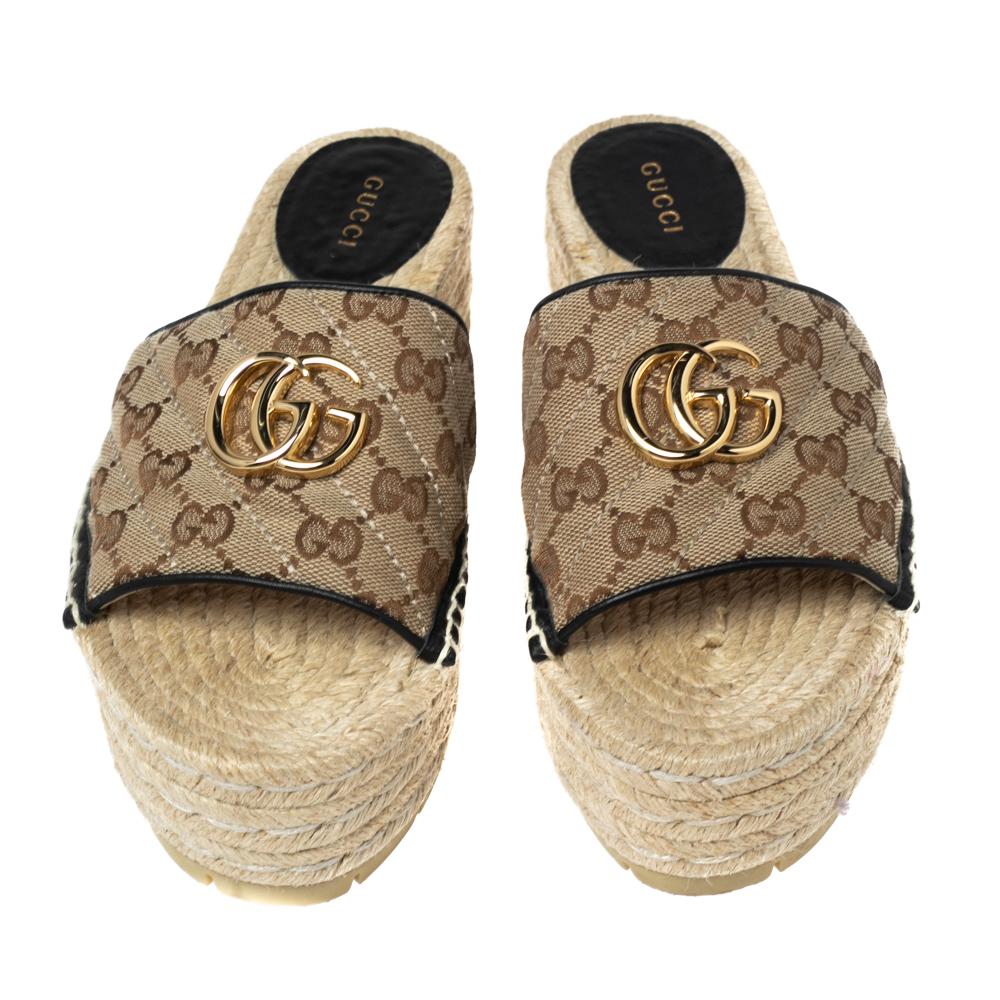 Grab these Gucci sandals that will get you that chic and casual look. Featuring GG coated canvas strap on the front and leather trims that are further adorned with GG motifs, these slides have peep toes, leather-lined insoles, and 11 cm espadrille