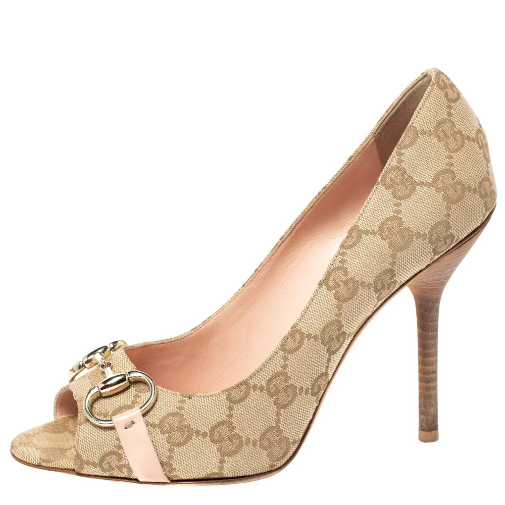 These classic Gucci peep-toe pumps make for an ideal formal and informal accessory. Crafted in beige GG coated canvas, they feature the brand's signature Horsebit in gold-tone on the vamps and come with 11.5 cm heels and leather insoles and soles.