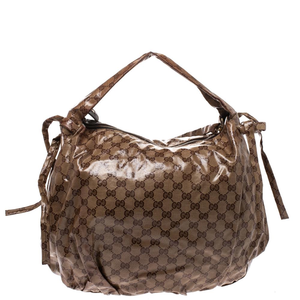 This Gucci hobo is built for everyday use. Crafted from the brand's signature GG crystal canvas, it has a beige exterior and a single handle for you to easily parade it. The nylon-lined interior is sized well and comes with a zip pocket. The stylish