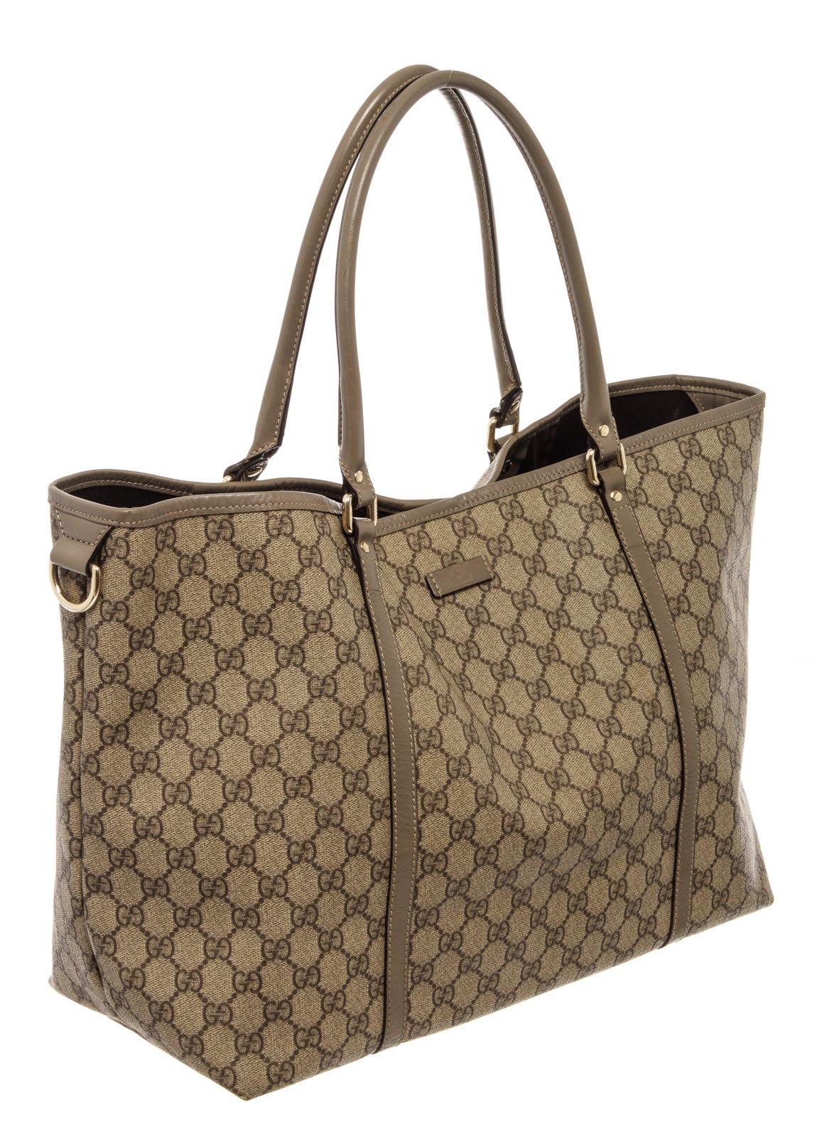 Gucci tote bag features a beige GG Monogram canvas body with brown PVC leather trim, dual rolled leather straps, gold-tone hardware, an open top with a magnetic snap button closure, brown woven canvas lining and interior zip and slip pockets.

