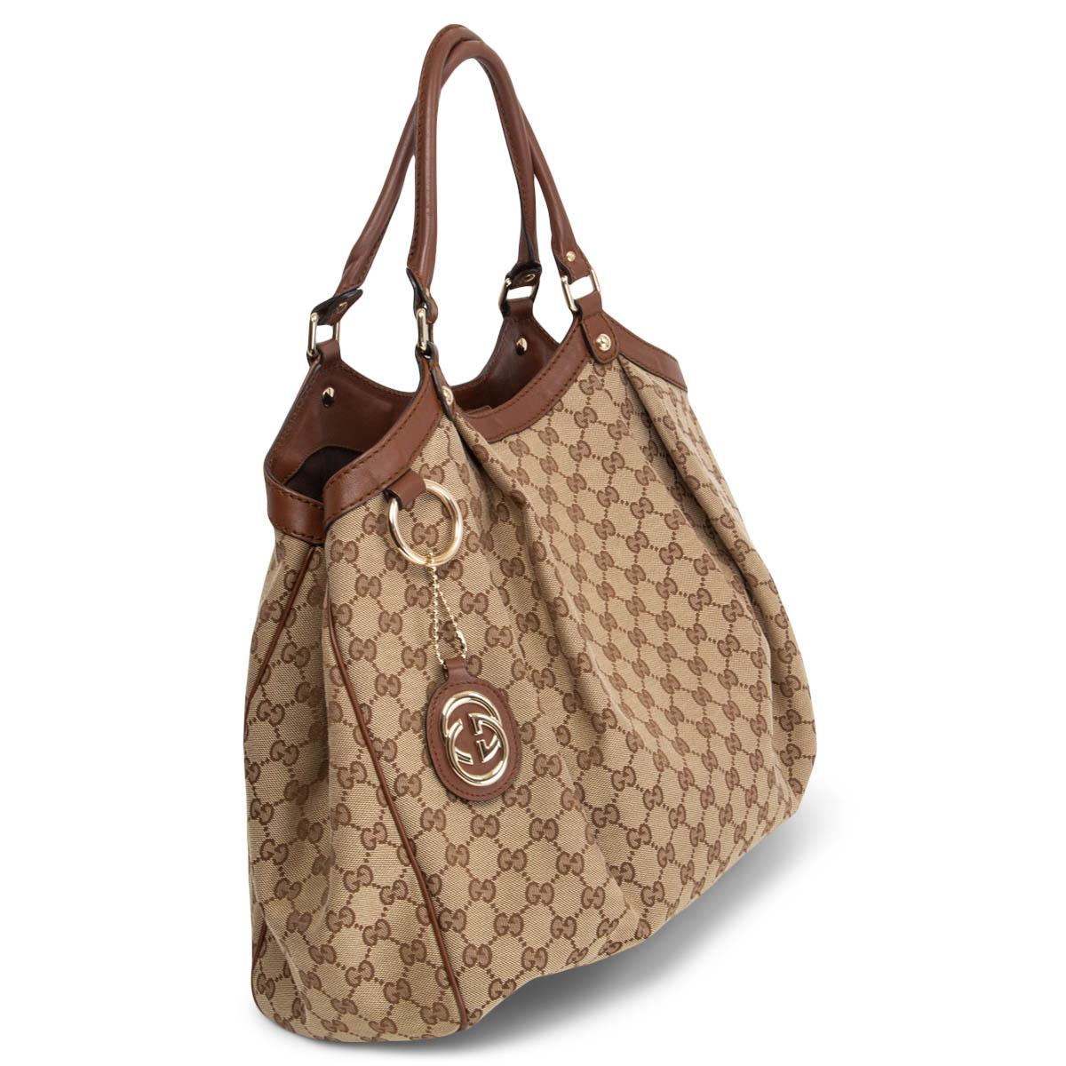 100% authentic Gucci 'Sukey Large' tote in beige and ebene signature GG monogram canvas with brown leather trimming featuring GG logo charm. Opens with a magnetic closure on top and is lined in brown canvas with one zip pocket against the back. Has