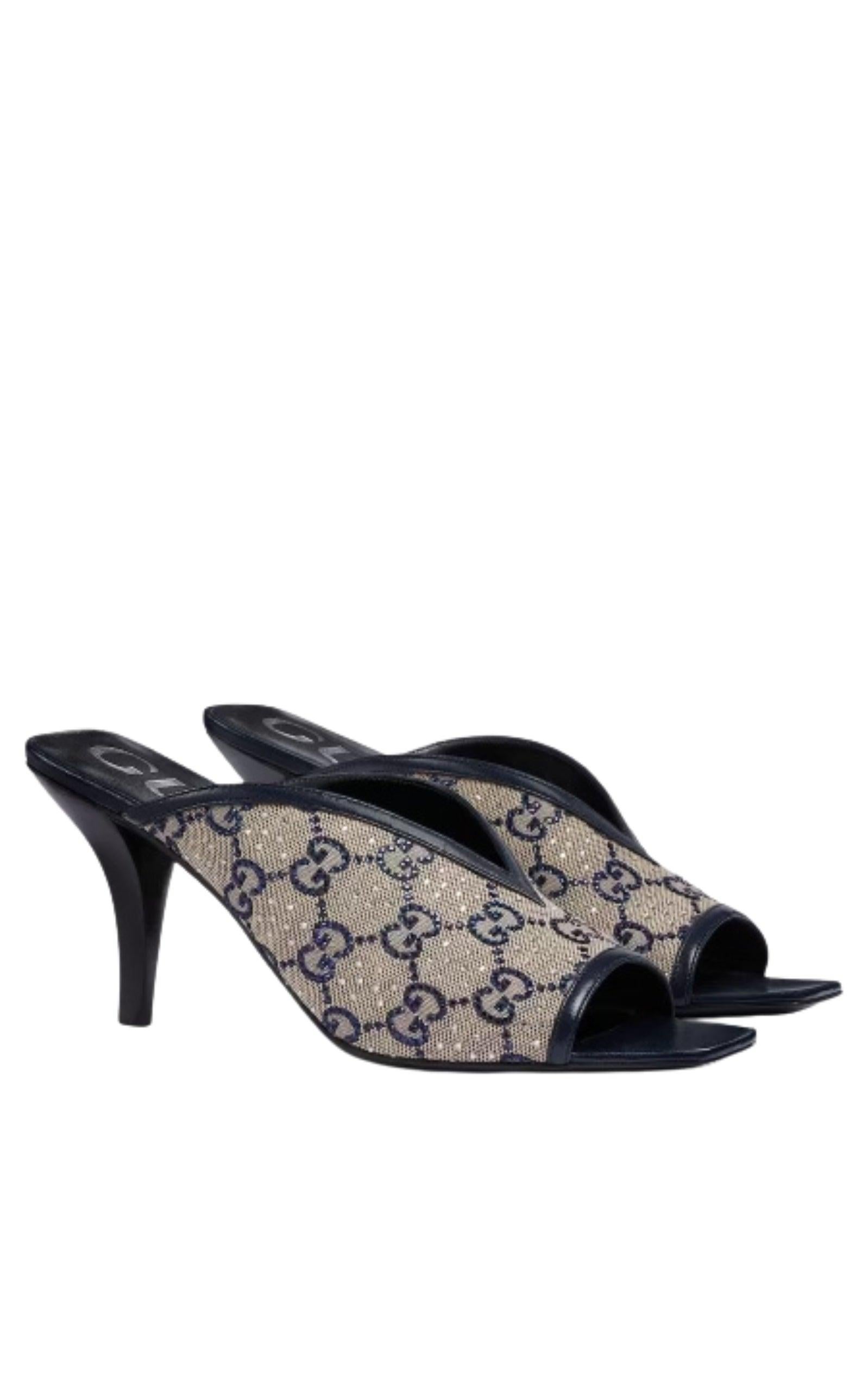 Premium leather and GG Supreme canvas are used to craft a chic open-toe sandal with a mid-height heel. The style features a beige and sapphire colourway, detailed with dazzling crystal GG embellishments and finished with a GG crystal logo on the