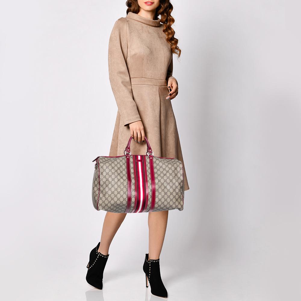 This trendy duffle bag from Gucci is a buy you won't regret! Crafted from the signature GG Supreme canvas and styled with leather trims, the bag flaunts the well-known Web details and has a well-sized fabric interior and two top handles for you to