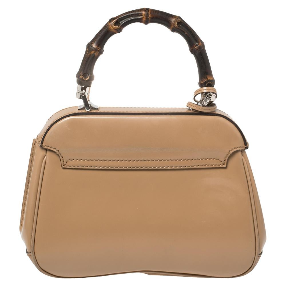 Handbags as fabulous as this one are hard to come by. Crafted from glazed leather, this stunning Lady Lock features a silver-tone lock and key holder. The spacious interior houses pockets to safely hold your necessities. The beige bag is held by a