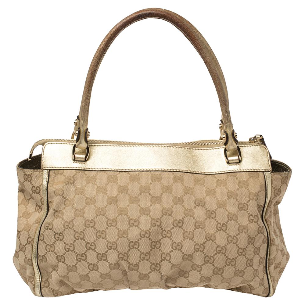 Gucci's classic Abbey D-Ring tote is a timeless accessory. Made in Italy, this beige creation is crafted from GG canvas and features gold leather trims and handles. It opens to a fabric-lined interior with enough space to hold all your daily