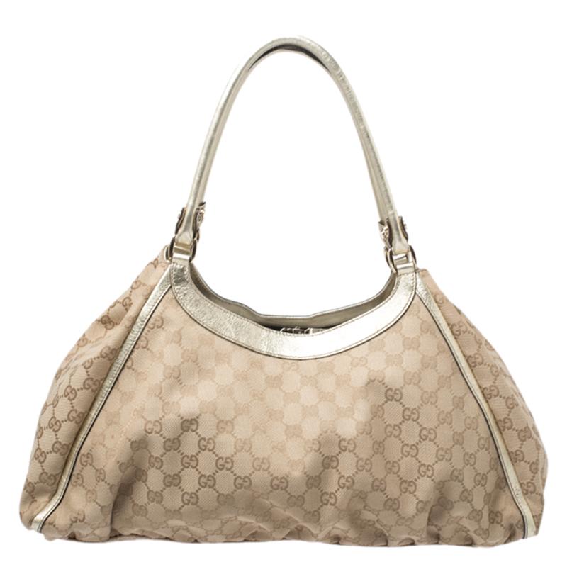 Gucci brings to you this amazing D Ring bag that is smart and modern. Made in Italy, it is crafted from classic GG canvas & leather and comes in lovely hies of beige and gold. It features dual handles and the top zipper reveals a fabric-lined
