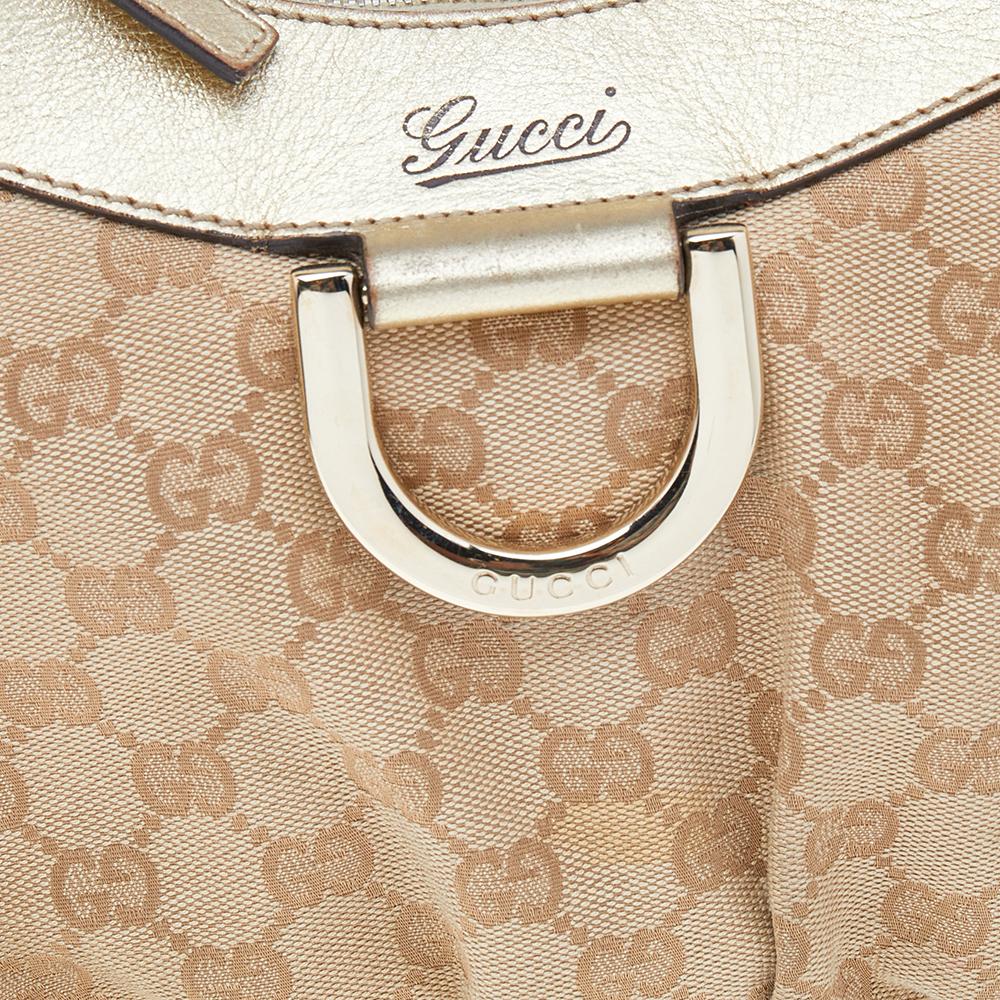 Gucci präsentiert Ihnen diese erstaunliche D Ring Hobo, die elegant und modern ist. Diese in Italien gefertigte beige-goldene Hobo ist aus GG Canvas und Leder gefertigt und verfügt über einen einzelnen oberen Griff. Der Reißverschluss an der