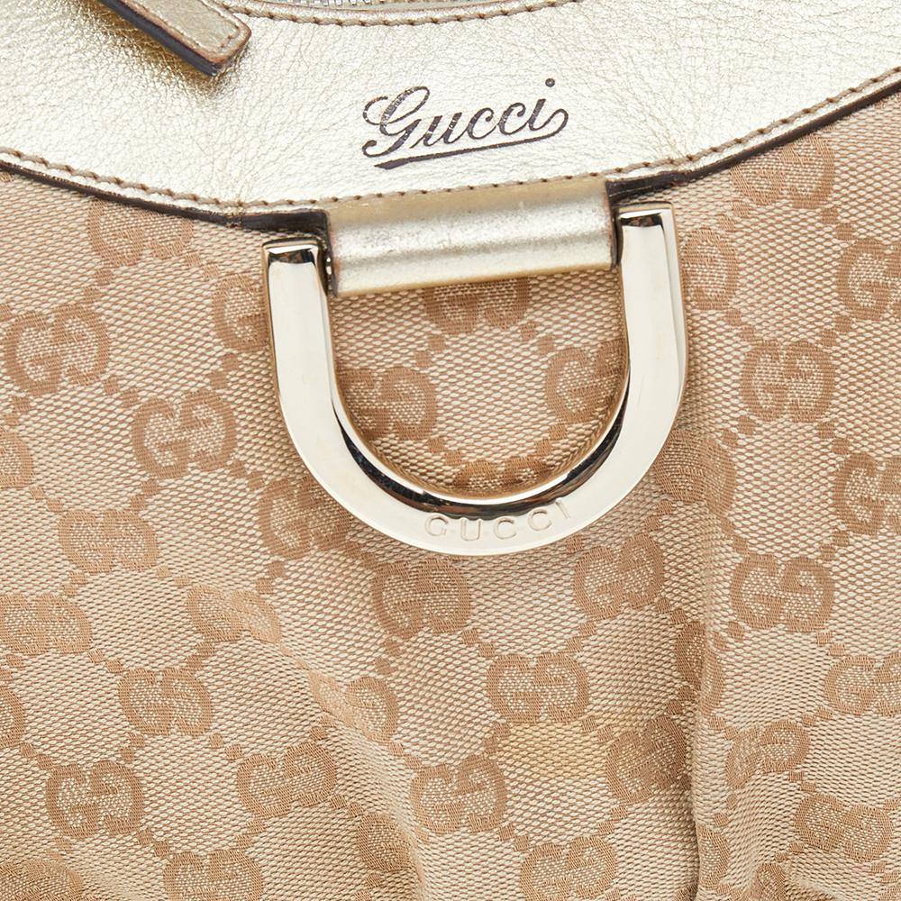 Gucci ti propone questa fantastica hobo con anello a D che è elegante e moderna. Realizzata in Italia, questa hobo beige e oro è realizzata in tela e pelle GG e presenta un unico manico superiore. La cerniera superiore rivela un interno foderato in