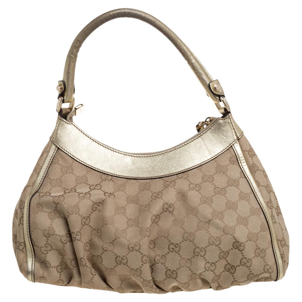 Gucci brings to you this amazing D Ring hobo that is smart and modern. Made in Italy, this beige & gold hobo is crafted from GG canvas and leather and features a single top handle and a D shaped ring at the front. The zip fastening at the top