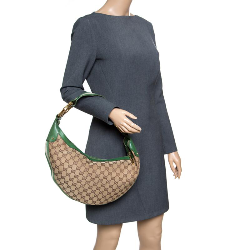 You are going to love owning this hobo from Gucci as it is well-made and brimming with luxury. The bag has been crafted from GG canvas and enhanced with green leather trims as well as fabric stripes. It is complete with a single handle, bamboo rings