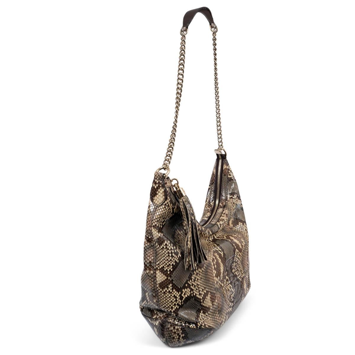 100% authentic Gucci Soho shoulder bag in beige, brown and taupe python. Features a GG patch on the front. Closes with a zipper with tassel pull on top. Lined in beige canvas with two open pockets against the front and a zipper pocket against the