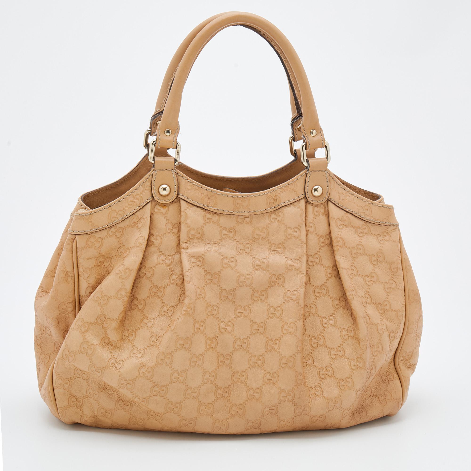 Enriched with signature details, this Sukey hobo from Gucci will surely win your vote as a favorite. It comes crafted from Guccissima leather and flaunts dual handles at the top, gold-tone accents, and neat pleats. Lined with canvas, its spacious