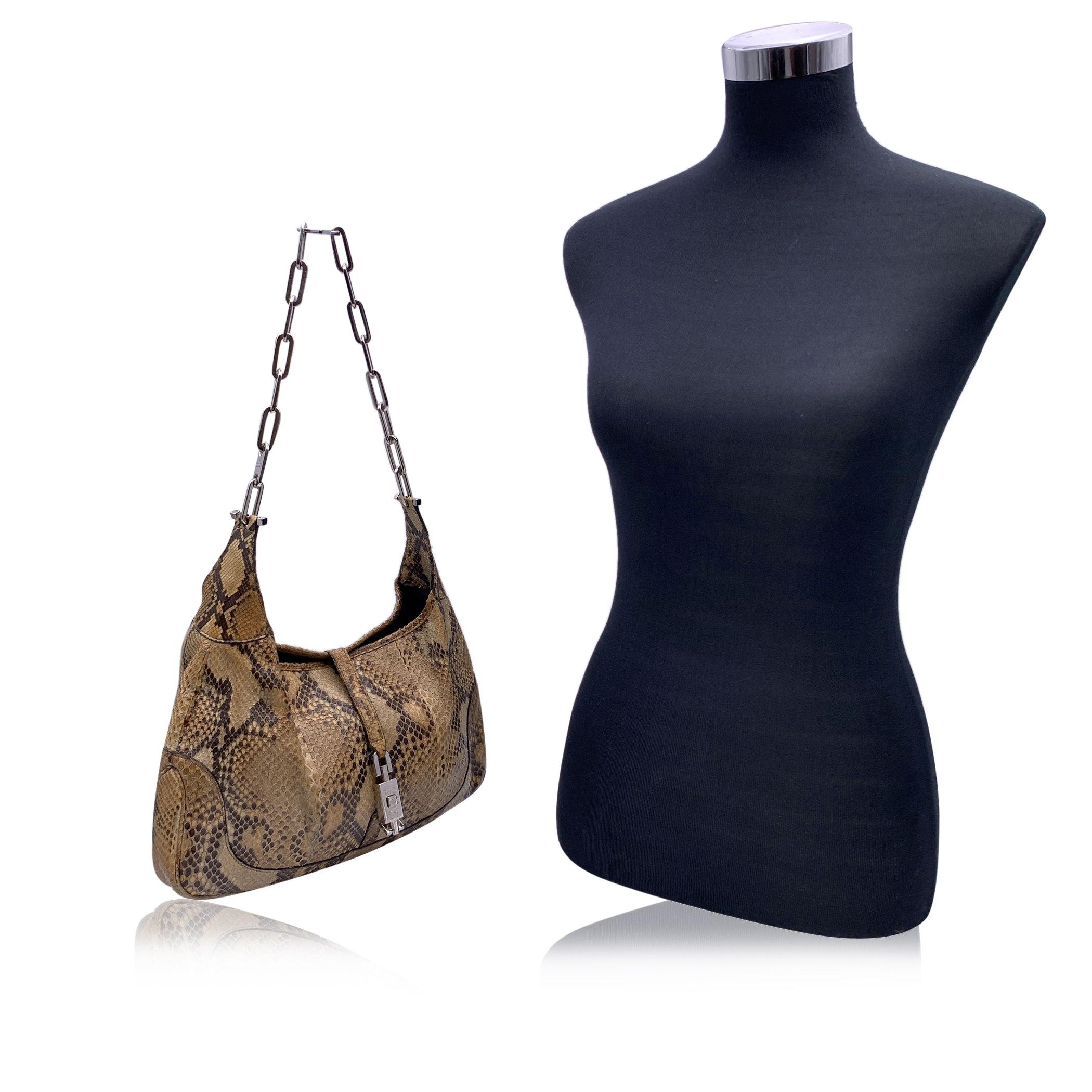 Beautiful Gucci Jackie Bag from the Tom Ford era, characterized by the classic squared Jackie closure. The bag is crafted in beige leather with silver metal chain strap. Fold over strap with silver metal push lock closure. Canvas internal lining. 1