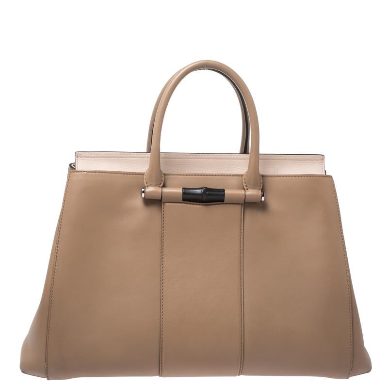 Own this gorgeous Gucci Lady Bamboo bag today and light up your closet! Crafted from leather, this stunning number has a top closure that opens to a leather interior. It also features two top handles, protective metal feet, and silver-tone hardware.