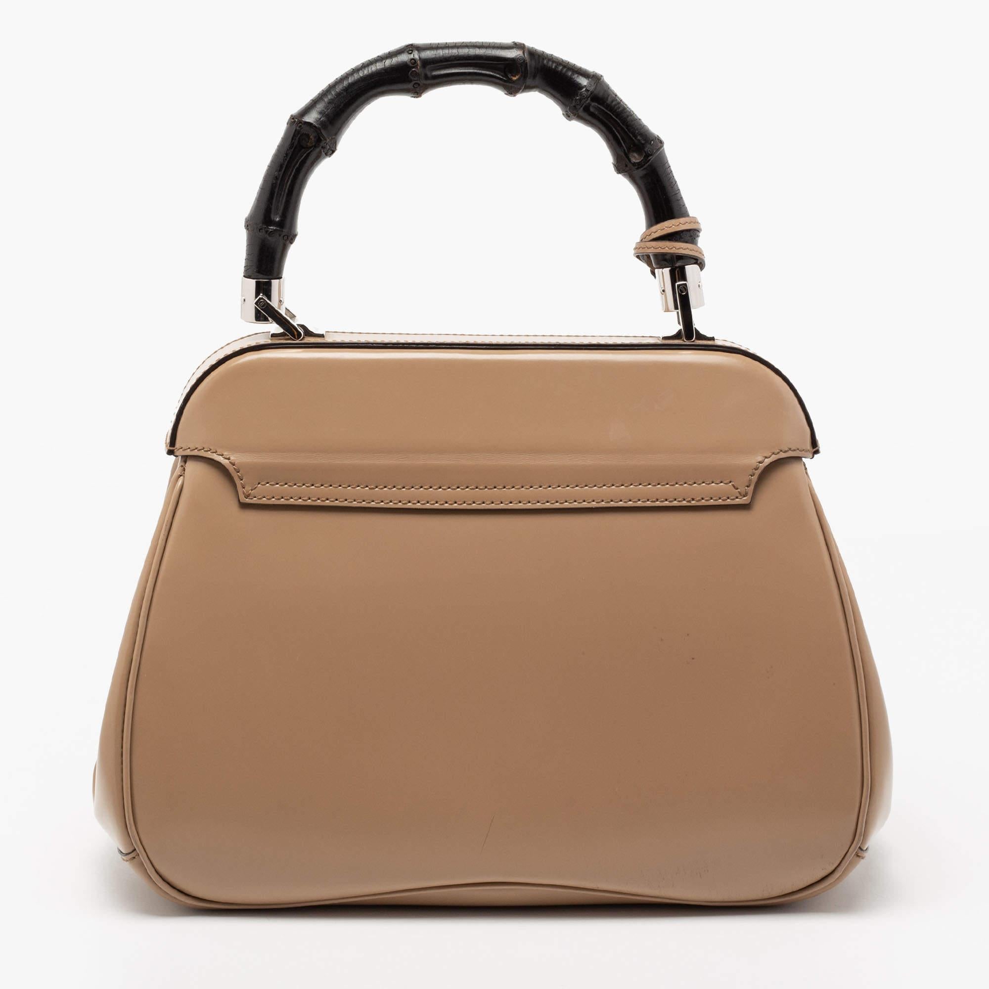 A lovely silhouette and minimal details make this handbag from Gucci a covetable piece! It is made of leather and features a silver-tone metal lock on the flap and a luxurious bamboo handle on top. The bag opens to a suede-lined interior.

Includes: