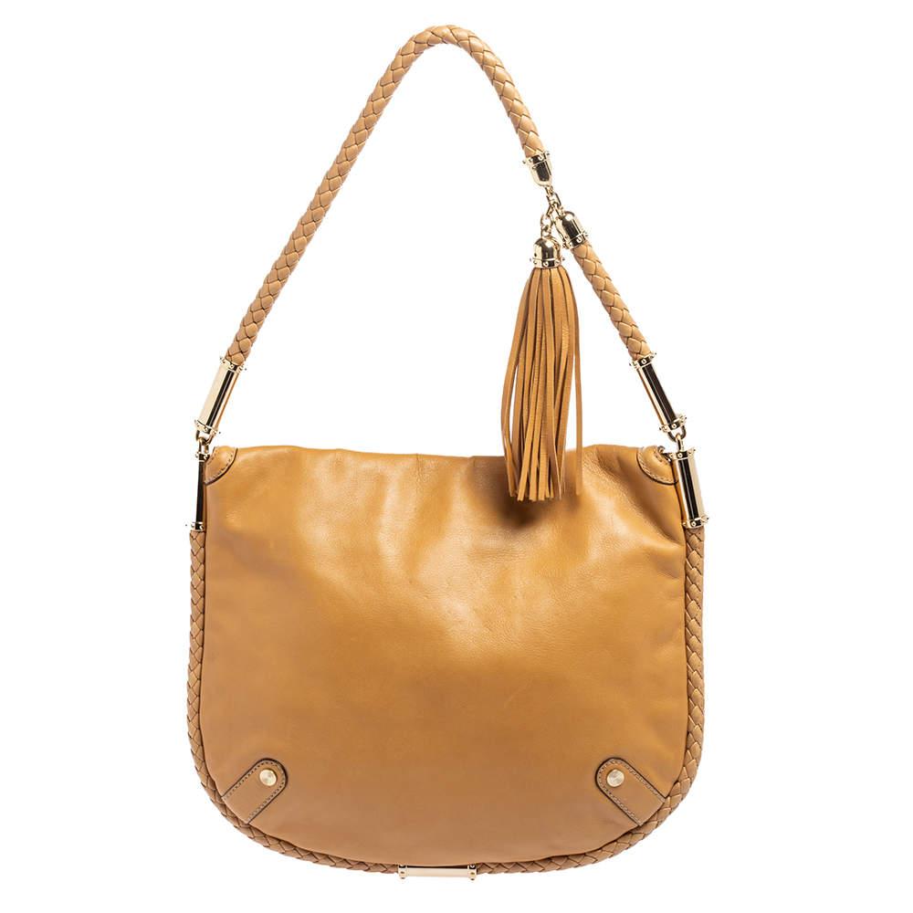 Keep your day look refined yet casual with this Britt hobo by Gucci. Made from leather, it is decorated with a GG logo on the flap and a tassel is added to the single top handle. The spacious interior is lined with striped fabric.

