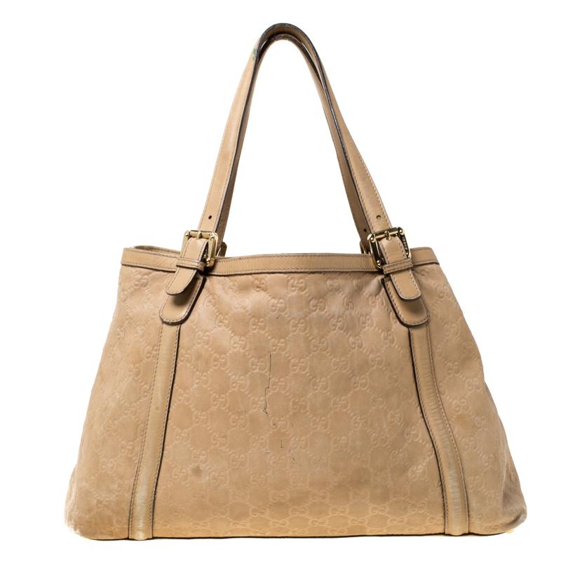 The iconic Gucci label has become renowned for its rich heritage and classic styles. This tote is made from beige leather and comes with dual top handles. It features a bold gold-tone GG logo embellished at the front. The fabric-lined interior is