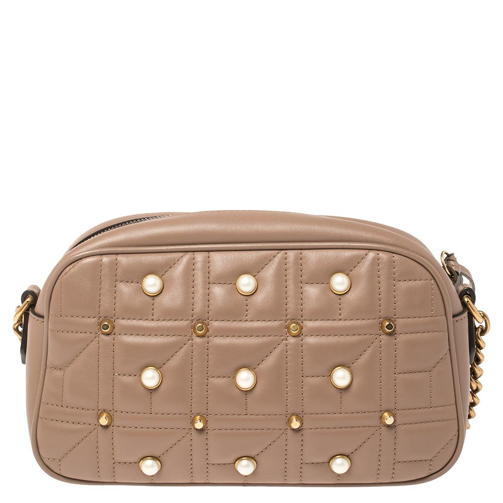 This GG Marmont shoulder bag encapsulates Gucci's maximalist vision. A traditional flap-top shape with a gold-tone sliding chain and leather shoulder strap, this quilted-leather piece is embellished with pearl and metal studs, then branded with a