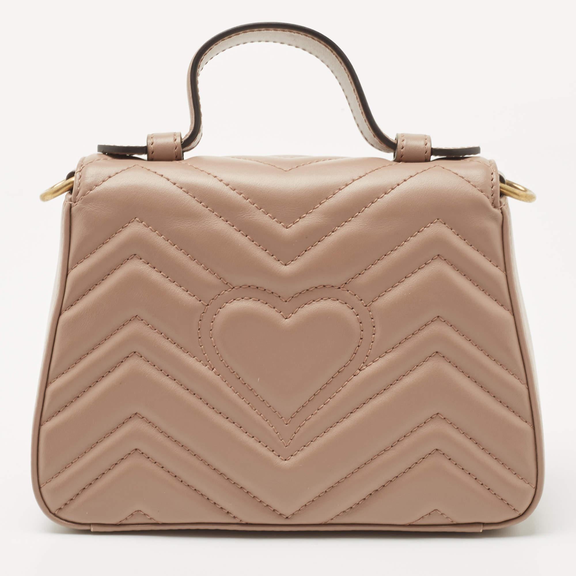 Este bolso de asa superior GG Marmont ha sido exquisitamente confeccionado en piel matelassé y equipado con un interior de Alcantara de gran tamaño. Hay un logotipo GG brillante en la solapa delantera, y la correa desmontable para el hombro permite