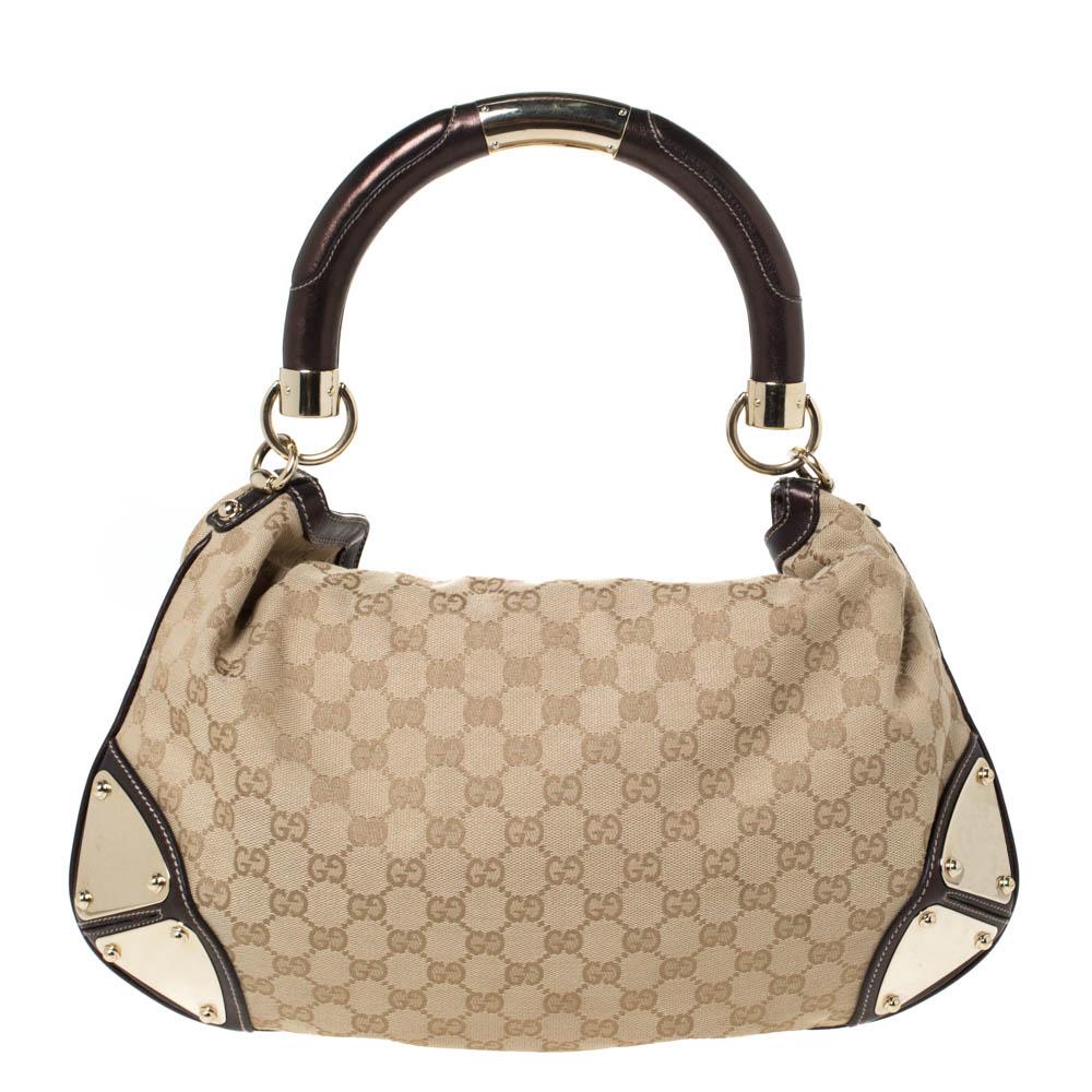 Crafted from GG canvas and leather, this Gucci number has a top with two bamboo-detailed mink tassels and a spacious fabric interior. It also features a sturdy top handle, armoured corners, and gold-tone hardware. Flaunt this beauty wherever you go