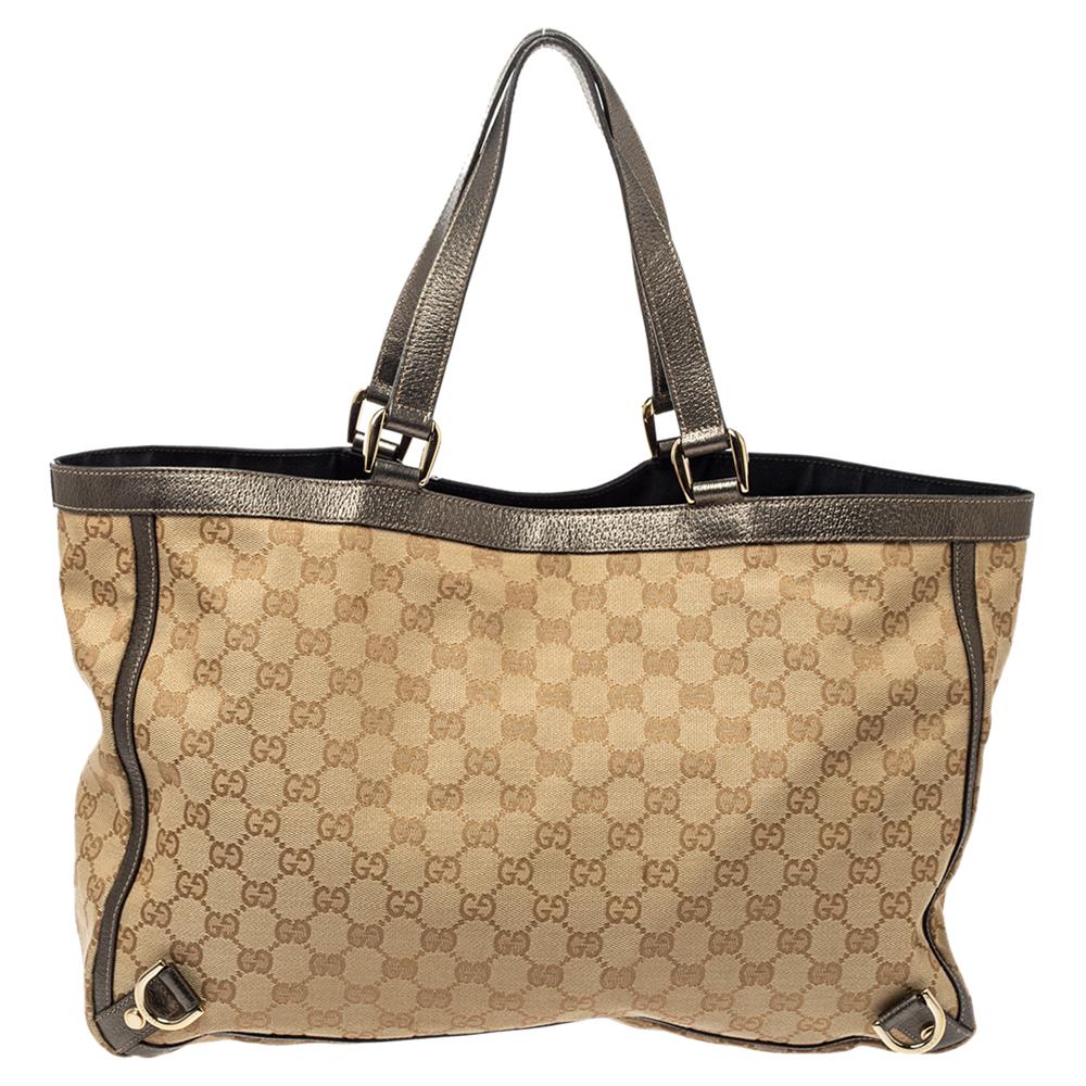 Gucci brings to you this Abbey tote that is smart and modern. Made in Italy, this beige and metallic creation is crafted from GG canvas and features a single top leather handle. The top zipper reveals a fabric-lined interior with enough space to