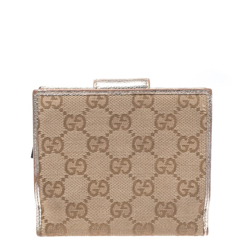 Mit dieser kompakten Abbey D Ring Brieftasche von Gucci sind Sie immer gut organisiert. Sie ist aus GG-Canvas gefertigt und kommt in schönen Beige- und Metallic-Goldtönen daher. Es hat das D-Ring-Motiv auf der Vorderseite. Das Portemonnaie verfügt