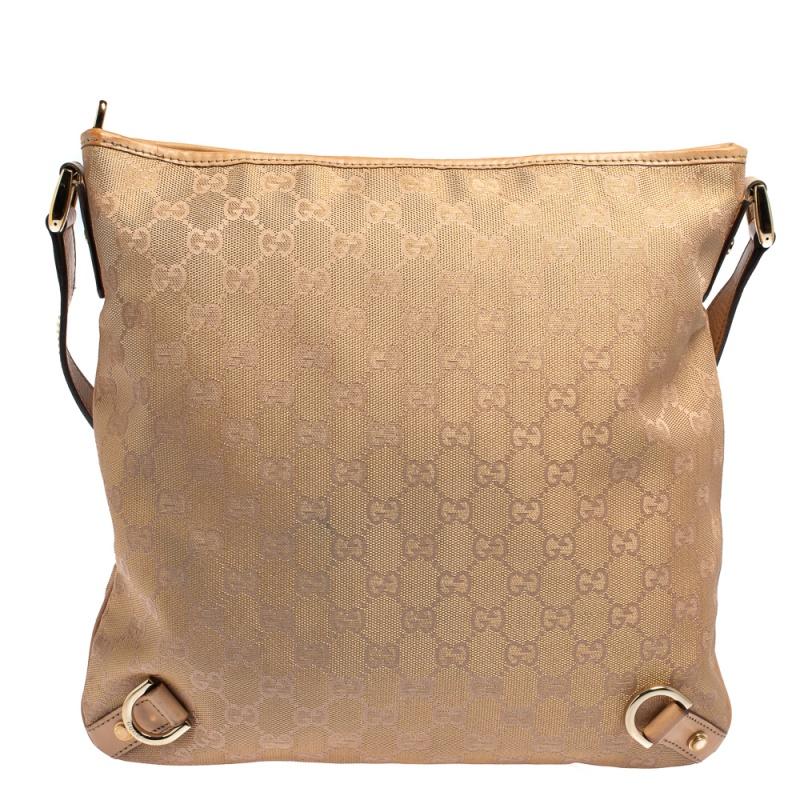 This stunning Abbey D-Ring bag from Gucci is crafted from the classic GG canvas & leather. The beige & metallic pink bag comes with a shoulder strap. Lined with fabric on the interior, the bag has gold-tone D rings on the front. With a spacious