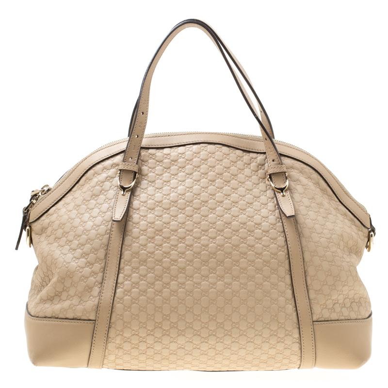 Meticulously crafted from Microguccissima patent leather, this Gucci bag delights not only with its appeal but structure as well. It is held by two top handles, detailed with gold-tone hardware and equipped with a spacious canvas interior. The