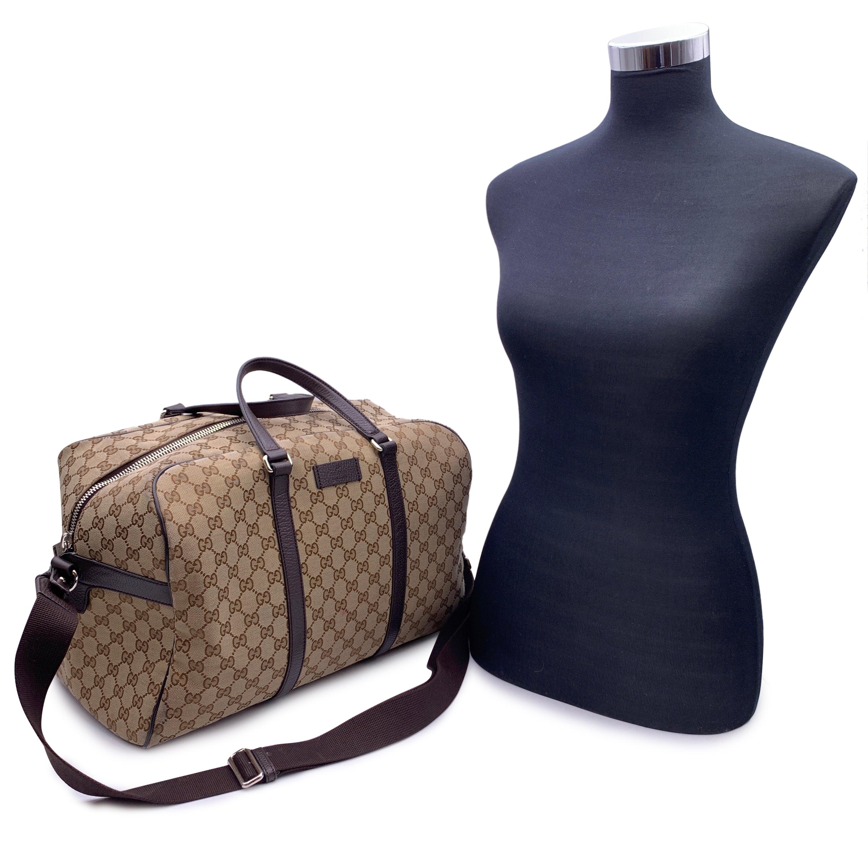 Beautiful duffle travel bag by Gucci. Crafted in beige monogram camvas It features the Gucci name patch on the front, double handles, upper zipper closure and fabric lining. 1 side zip pocket inside. Adjustable and removable shoulder strap. 'GUCCI -