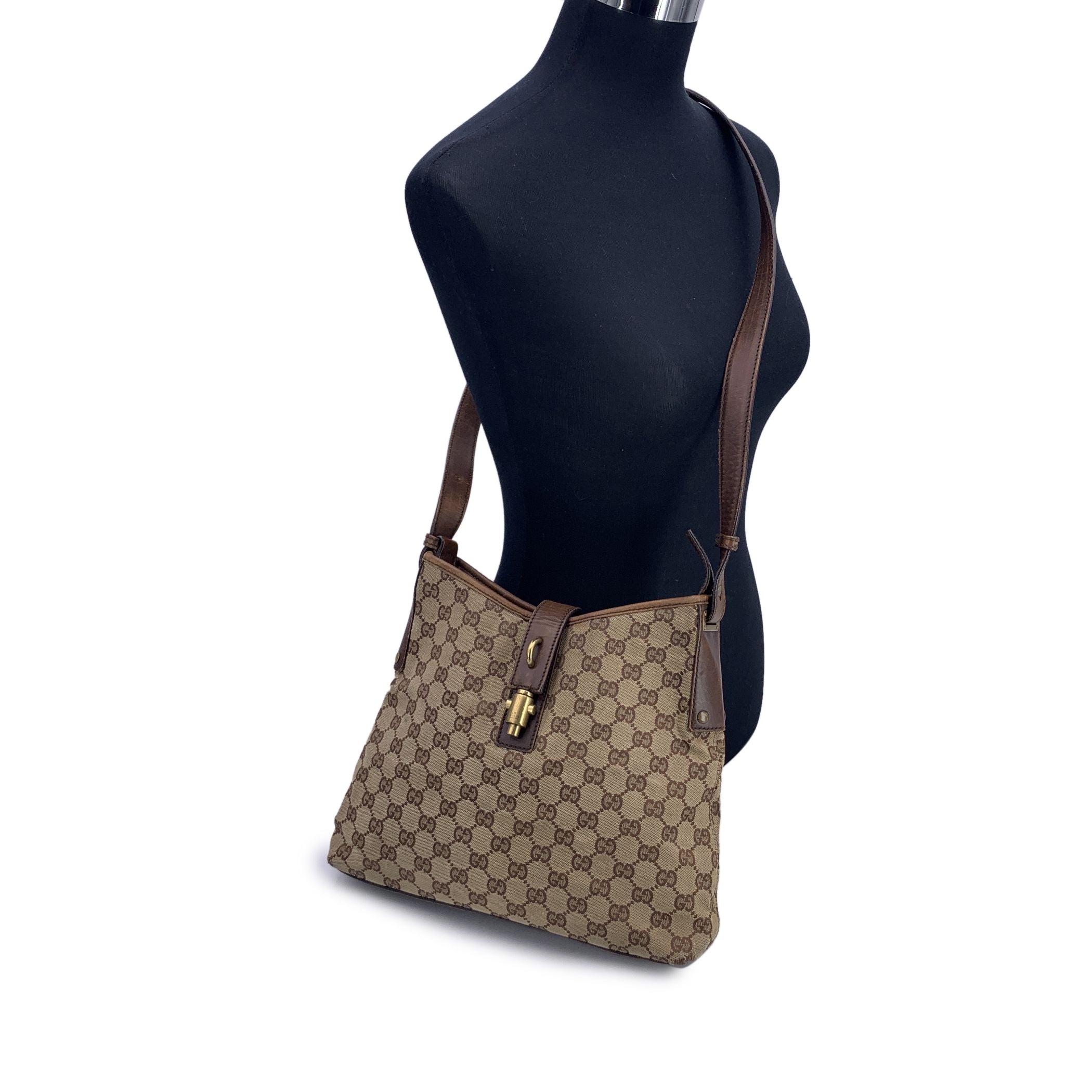 Step into a world of classic luxury with this beautiful Gucci shoulder bag, a perfect blend of understated elegance and functional design. Crafted from beige monogram canvas, the bag is accented with rich brown leather trim and a matching leather