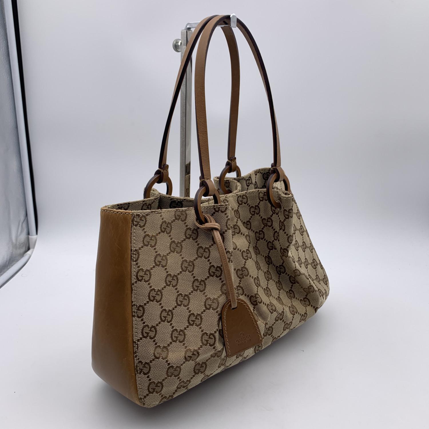 Gucci Monogram Tote bag. in beige monogram canvas with genuine leather trim and double leather handles. Magnetic button closure on top. Brown fabric lining and 1 zip pouch. 'GUCCI - Made in Italy' tag inside (with serial number on its