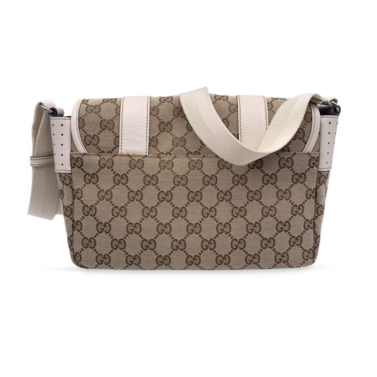 Gucci beige monogram canvas crossbody Bag. Beige canvas messenger bag with all-over GG - GUCCI monogram canvas and white leather trim. Adjustable canvas shoulder strap. Black leather trim. Flap with double hook and loop closure on the front. Brown