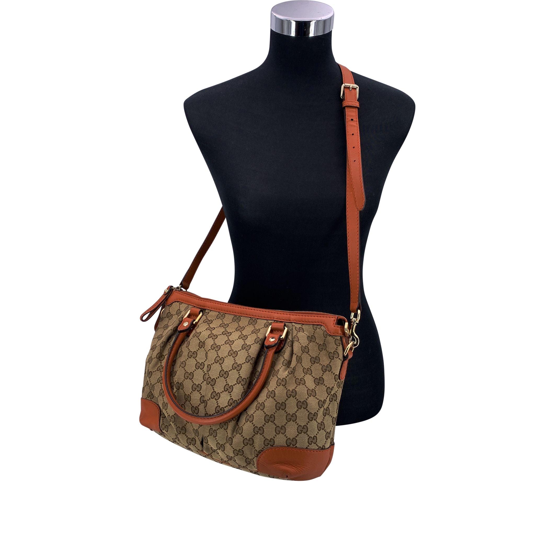 The Gucci Sukey Shoulder Bag is a timeless piece that captures the refined spirit of early 2000s Gucci design. Crafted from beige GG monogram canvas with orange leather trim, this authentic model (2000-2015) blends elegance with everyday