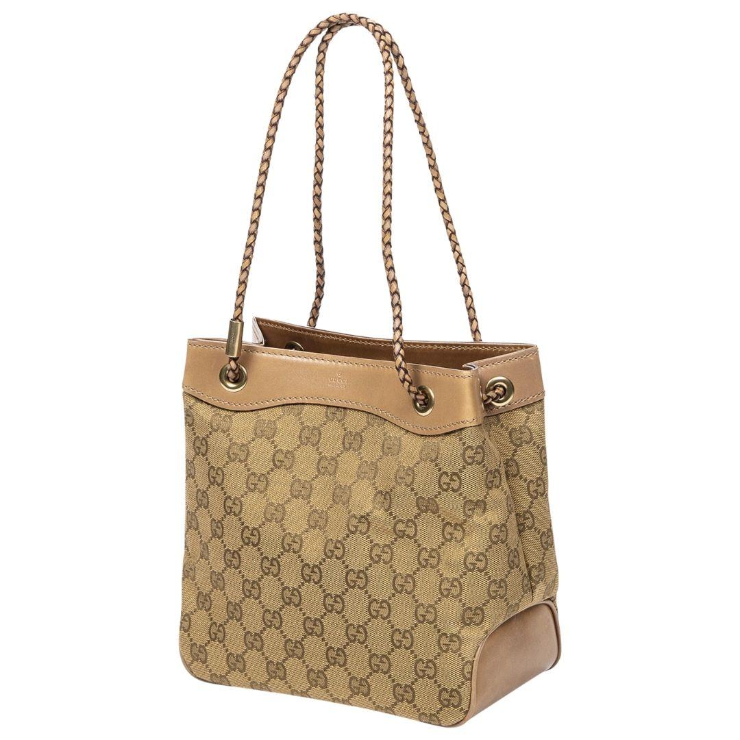 For my Gucci girls! This classic monogram tote is crafted in dark beige canvas with a contrasting light brown leather trim, gold-tone hardware, and dual braided straps. The open closure leads to a canvas interior with one zippered