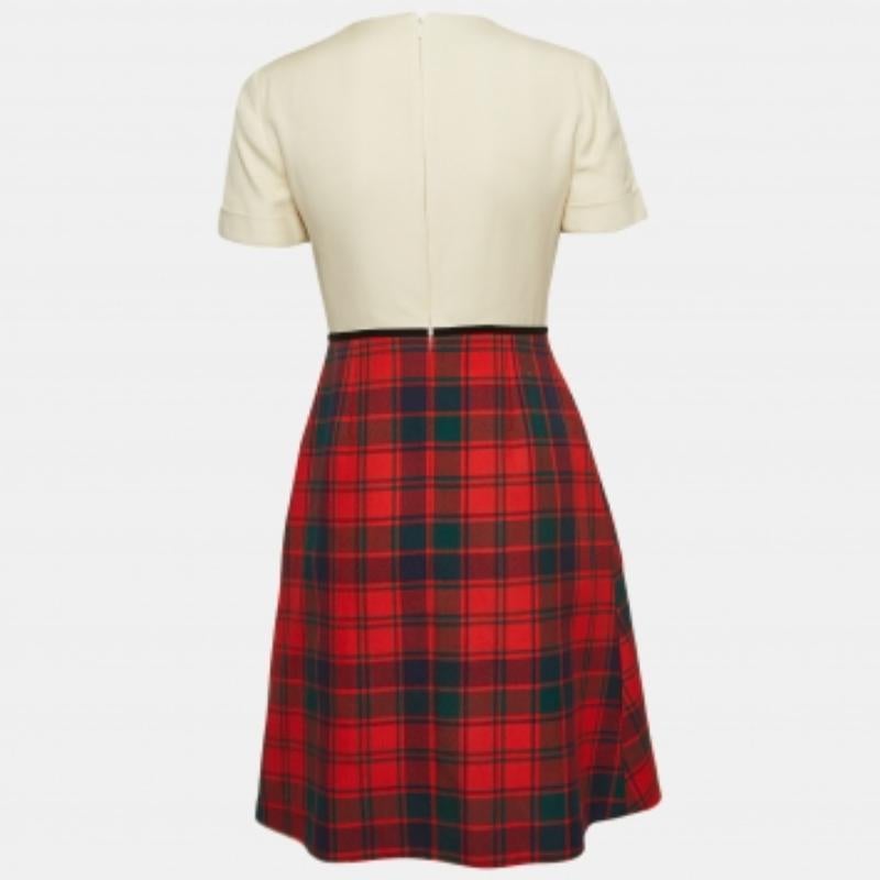 Cette robe Gucci présente des détails élégants et une silhouette chic. Composée d'un haut beige à manches courtes et d'une jupe à carreaux, cette robe se porte aussi bien avec des chaussures plates qu'avec des talons. Il est fabriqué à partir des