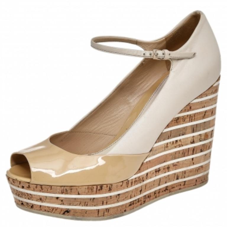 Ces ravissantes sandales Gucci vous apporteront la bonne dose de style et de brillance. Elles sont réalisées en cuir verni beige et en cuir et présentent des bouts pointus, un logo doré sur l'empeigne et des talons compensés en liège de 11,5 cm.